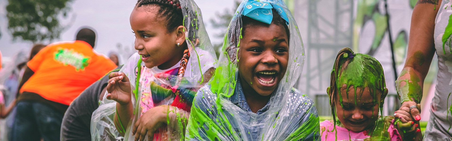 A group of children screaming in joy while covered with Nickelodeon green slime